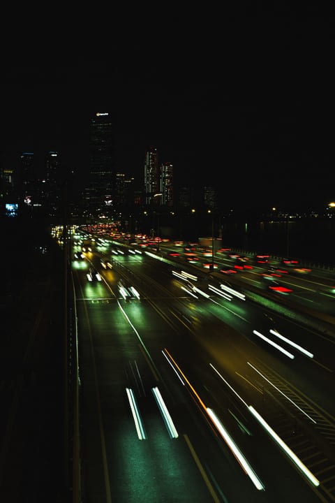 Long trails of vehicle lights on a city road at night
