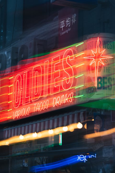 A red neon sign and colorful streaks of light