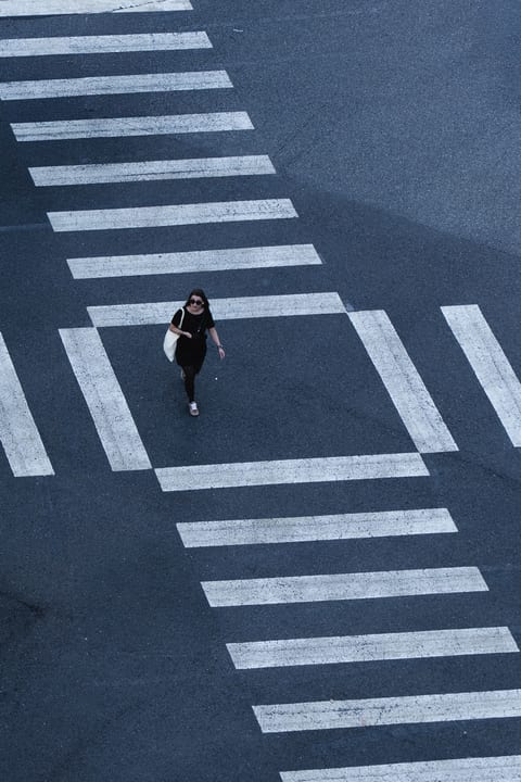 An overhead view of a person walking across a crosswalk